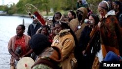 People gather on the shore of the East River during an indigenous sunrise water ceremony on Randall's Island as Indigenous Peoples' Day is observed in New York City, Oct. 9, 2023. 