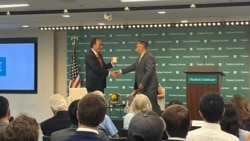 美国智库哈德逊研究所中国中心主任余茂春（Miles Yu)向海曼资本的创始人巴斯(Kyle Bass)7月13日向赠予印有小熊维尼的杯子。巴斯当日发表了关于中国国家主席习近平发动战争时间表的演讲。（美国之音记者薛小山拍摄）