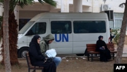 2024年1月28日，流离失所的巴勒斯坦人坐在长椅上，在加沙地带南部拉法的联合国援助机构的诊所外等候。（法新社照片）