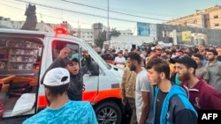 资料照片：2023年11月3日，人们聚集在加沙城希法医院前一辆据称在以色列袭击中受损的救护车周围。（法新社照片）