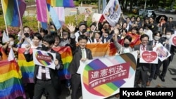 日本一家法院裁定，不允许同性婚姻是违宪后，日本民众挥舞彩虹旗帜和标语庆祝。（2023年5月30日）