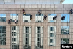 清洗高層建築玻璃的工人繼續在北京高溫天氣中工作。（2023年6月22日）