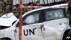 FILE - Lebanese soldiers stand behind a damaged vehicle after a UN peacekeepers convoy came under fire in the Al-Aqbiya village, south Lebanon, Dec. 15, 2022. 
