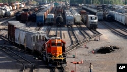 资料照片：BNSF铁路公司的工人在伊利诺伊州盖尔斯堡看着货运列车驶离货运站。(2021年6月15日)