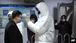 一名乘客星期天（1月26日）在北京地铁接受体温检测。