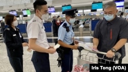 香港警方聯同入境處人員8月20日下午在香港國際機場，向準備前往泰國曼谷的旅客派發傳單，呼籲他們小心東南亞詐騙集團求職騙案。（美國之音湯惠芸）