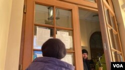 一名妇女正在阅读一份需要帮助解决紧急需求的志愿者名单（美国之音德特默拍摄）。