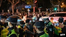 2022年11月27日，在上海烏魯木齊路舉行抗議的人群與警察。（法新社）