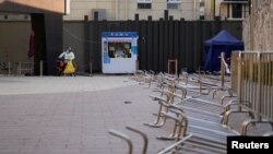 身穿防护服的工作人员在等候上海市民前来做新冠核酸检测。（2022年12月22日）