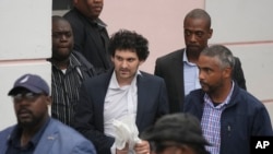 FTX 創始人山姆·班克曼-弗里德（中）在同意被引渡到美國後，於2022年12月21日從巴哈馬拿騷地方法院護送出來。 （美聯社照片）