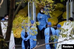 上海一家火葬场的工作人员走过数个逝者的尸袋。（2023年1月4日）