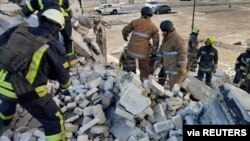 在2022年3月18日發布的這張圖片中，隨著俄羅斯對烏克蘭的攻擊繼續，救援人員正在烏克蘭哈爾科夫一棟被砲擊損壞的住宅樓的廢墟中搜尋。