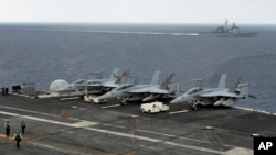 參加在印度南部港口金奈附近海域舉行的印美日聯合軍演的美國“西奧多·羅斯福”號航空母艦。附近為美國海軍"諾曼底"號導彈巡洋艦。 （2015年10月17日）