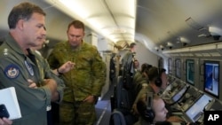 印太美軍司令約翰∙阿奎利諾（左）海軍上將在美國海軍一架飛臨南沙群島上空的P-8A“波塞冬”偵察機上觀看中國在人工島上建造的建築物的視頻。(2022年3月20日)