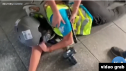 印尼女记者英达(Veby Indah)被橡皮子弹打中右眼倒地瞬间。（美国之音电视画面视频截图）