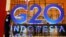 一名保安站在二十国联合峰会峰的巨大招牌旁，二十国卫生和财政部长即将在印尼巴厘岛参加这次峰会有关健康、可持续能源及数码转变加的讨论，然而俄乌冲突、美中与西方国家日益紧张的关系或将始终是这次会议挥之不去的阴影。