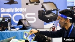 台灣一名戴著口罩和面罩的工作人員在為台北國際電腦展覽會開幕做準備。（2022年5月24日）