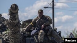 烏克蘭頓涅茨克地區的一名烏軍士兵坐在坦克車頂上。（2022年5月25日）