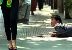 资料照：上海街头的一名残疾乞讨者