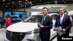 中國外交部新任部長秦剛（照片中前者）與美國通用汽車公司總裁馬克·瑞烏斯2022年9月14日一同參觀在底特律舉辦的北美國際汽車展。