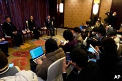 中国疾控中心流行病学首席专家吴尊友(右)在北京举行的记者会上讲话。（2022年12月29日）