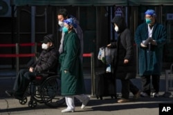 北京一家医院外一位坐轮椅排队离开发热门诊的老年病患。（2022年12月19日）