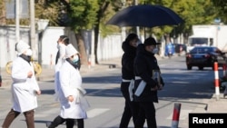 上海一家火葬场外身穿孝服的亲属手捧逝去亲人的遗像。（2022年12月23日）