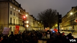 示威者拿着抗議標語牌在中國駐英大使館外示威。(美國之音/鄭樂捷）