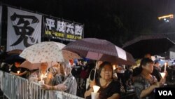 大批群眾冒雨留守在維園六四燭光晚會會場，堅持為六四死難者獻上燭光