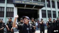 Un estudiante de magisterio protesta frente a la Corte de Constitucionalidad que es protegida por la policía, mientras participa de una marcha contra la privatización de la educación en Ciudad de Guatemala, el 26 de abril de 2007. 