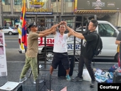 前中国“精神病监狱”受害者界立建和一群海外维权人士10月10日于美国洛杉矶好莱坞星光大道的中国剧院旁透过演示，还原中共利用名为“安康”的精神病监狱制度迫害异议人士的暴行(照片提供：界立建)。