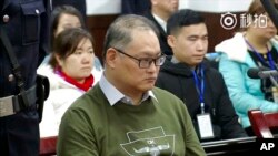 這張照片來自於2017年11月28日發布的一段視頻，當時在湖南省岳陽市岳陽市中級人民法院，台灣人權活動人士李明哲在法庭受審。