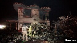 在巴格达以南的希拉市的一处加油站，伊拉克安全部队在检查自杀卡车炸弹袭击后的现场。（2016年11月24日）