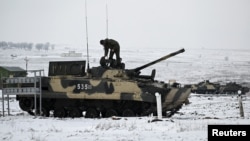 在俄羅斯的羅斯科夫地區卡達莫夫斯基靶場，一名軍人在南部軍區舉行演練期間站在一輛BMP-3步兵戰車上。(2022年1月27日)