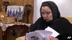 维吾尔族妇女早木热·达吾提从新疆拘留营获释后流亡美国。2020年6月15日在弗吉尼亚州伍德布里奇家中查看文件。她说：“我觉得我们的证词，我们致力于让国际社会提高认识的努力，终于得到了回报。”（美联社照片）