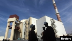 資料照：伊朗工人站在布什爾核電站前。