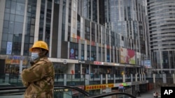 一名身穿工裝的工人乘坐電梯到達北京一個空蕩蕩的商貿區。（2023年1月11日）