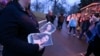 An attendant holds programs as fans enter Graceland for a memorial service for Lisa Marie Presley, Jan. 22, 2023, in Memphis, Tenn. 