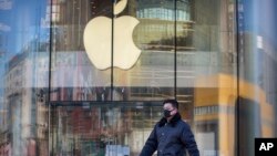 一名男子戴著口罩經過一家因新冠疫情暫時關閉的蘋果店。（2020年2月4日）