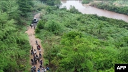 ພາບຖ່າຍໃບປິວ ຈາກກອງທັບໄທ ທີ່ຖ່າຍເມື່ອເດືອນເມສາ 2021 ແລະຖືກເປີດເຜີຍເມື່ອວັນທີ 3 ພຶດສະພາ 2021 ສະແດງໃຫ້ເຫັນທະຫານຄຸມຕົວພວກຍົກຍ້າຍຖິ່ນຖານຜິດກົດໝາຍ ໃນສະຖານທີ່ທີ່ບໍ່ຖືກເປີດເຜີຍ ລະຫວ່າງ ໄທ ແລະປະເທດເພື່ອນບ້ານ ມຽນມາ, ລາວ ແລະກຳປູເຈຍ. (Photo by Handout / ROYAL THAI ARMY / AFP)