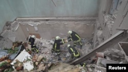 在利沃夫，救援人员在被俄罗斯导弹击中的一座居民楼废墟进行搜救工作。(2023年7月6日)