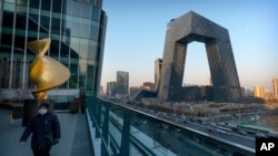 一名戴着口罩的男子在中国官媒中央电视台总部大楼附近的观景台行走。（2021年2月4日） 