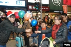 學民思潮召集人黃之鋒(左一)向途人派發聖誕氣球