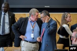 资料照片：世界卫生组织总干事谭德塞(右)在联合国会议上在与世卫组织紧急情况总干事迈克·瑞安交谈。