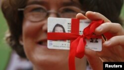 2007年9月15日來自英國的梁朱莉在北京舉行的“外國人開放日”中展示從市政府收到的永久居留“綠卡”。