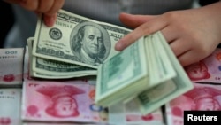 資料照：一名銀行職員在安徽省一家銀行里點數美元。