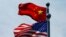 FILE - Chinese and U.S. flags flutter near The Bund, in Shanghai, China July 30, 2019. 