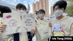 香港皇仁書院年宵籌委會主席伍正楓（右一）及成員Anthony (中）展示他們一班同學今年在荃灣南豐紗廠年宵市集售賣的自家設計”白玉兔“產品。(美國之音 湯惠芸)