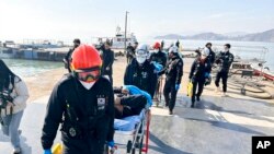Rescued crew members are carried on stretchers by rescue team as they arrive at a port in Mokpo, South Korea, Feb. 5, 2023.