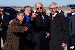 ປະທານາທິບໍດີສະຫະລັດ ທ່ານໂຈ ໄບ​ເດັນຄ່າຍ​ຮູບ​ແບບ​ແຊ​ລ​ຟີ ຮ່ວມ​ກັບທ່ານ Tony Evers, ຜູ້​ປົກ​ຄອງ​ລັດ​ວິ​ສ​ຄອນ​ຊິນ (ຂວາ) ຫຼັງ​ຈາກ​ໄປ​ເຖິງສະ​ໜາມ​ບິນຖານ​ທັບ​ພິ​ທັກທາງ​ອາ​ກາດ Truax Field Air National Guard Base, ວັນ​ທີ 8 ກຸມ​ພາ, 2023, ໃນ​ເມືອງ​ເມ​ດິ​ສັນ, ລັດ​ວິ​ສ​ຄອນ​ຊິນ.